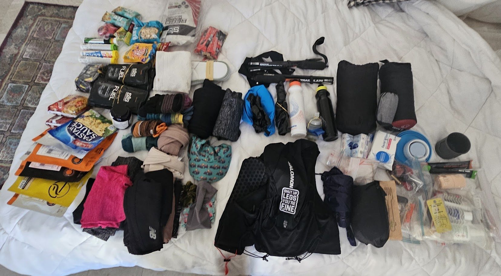 Full self-supported race kit laid out: pack, sleeping bag, food, mandatory equipment