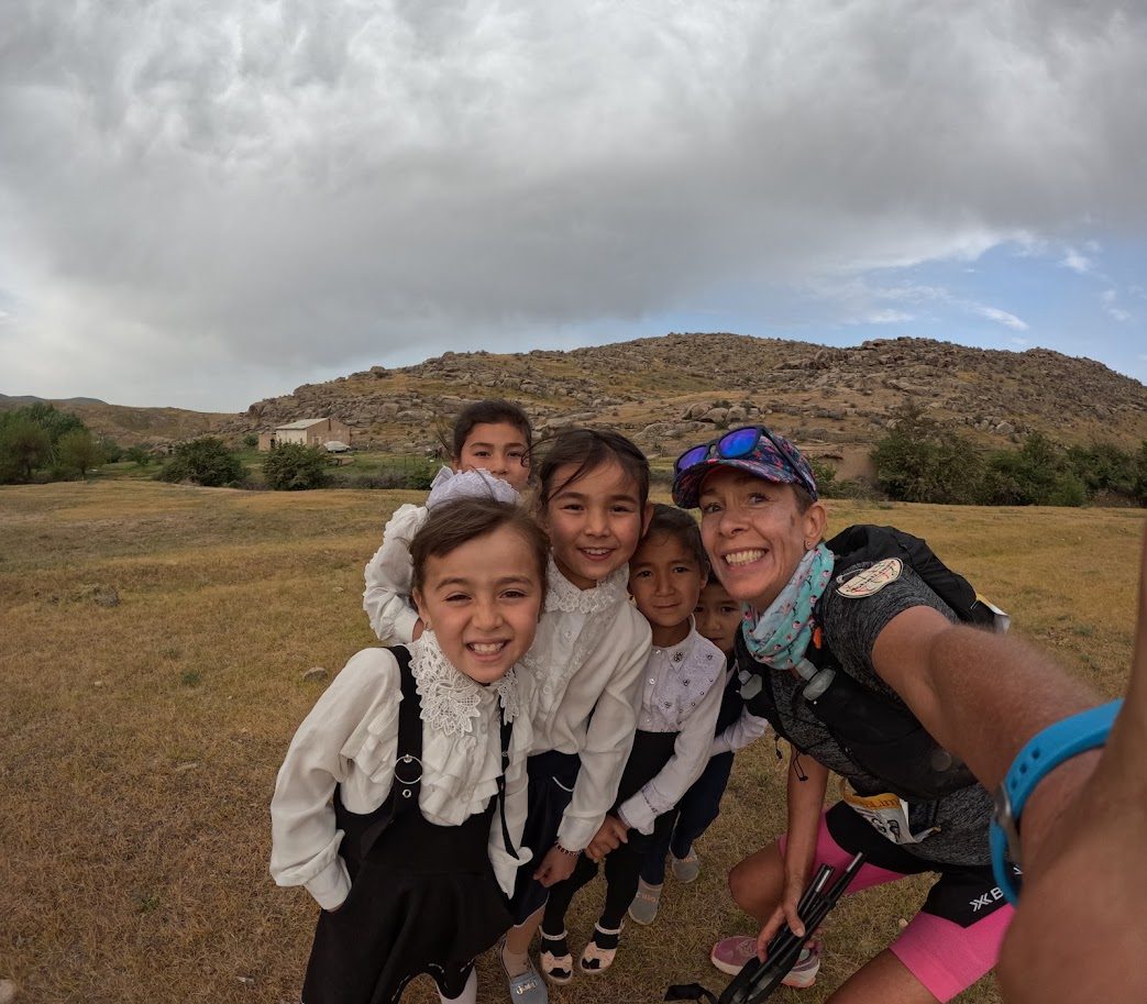 Lisa with a group of local children mid-race in rural Uzbekistan